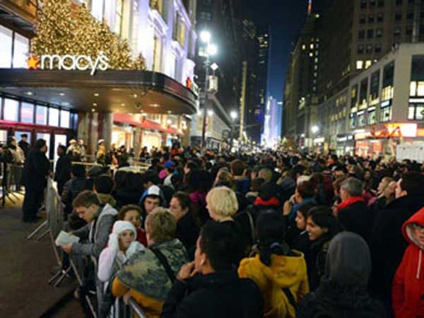 Shoppers at night waiting outside Macy's department store.