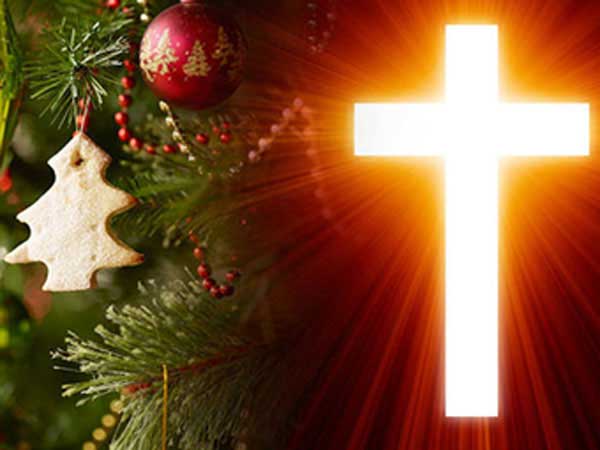Glowing cross with decorated Christmas tree.