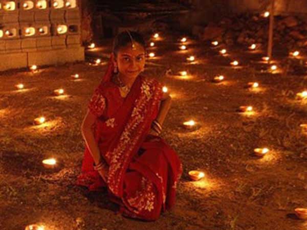 Girl celebrates Diwali with diyas (oil lamps).