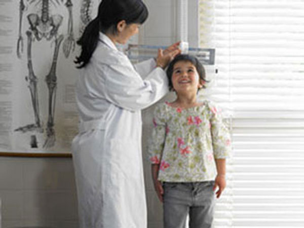 Young girl having her height measured by doctor.
