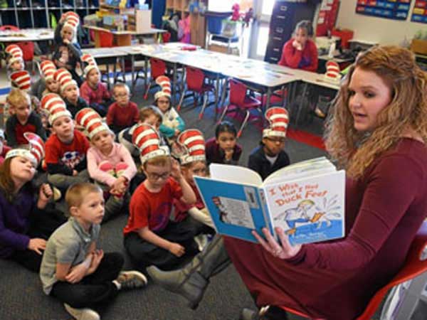 Teacher reads Dr Seuss book to children.