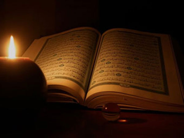 Koran lit by candlelight. 
