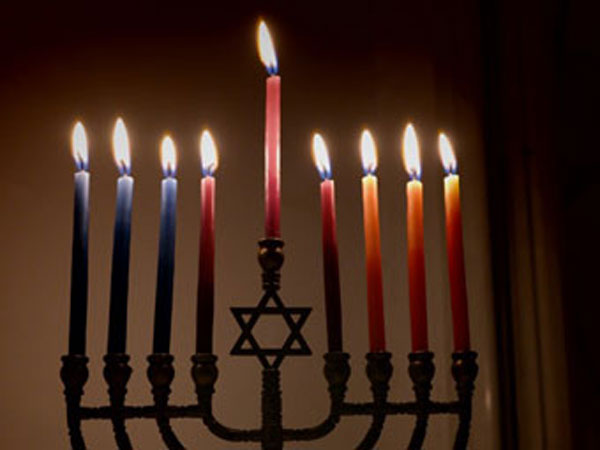 Colorful candles lit on the menorah for Hanukkah.