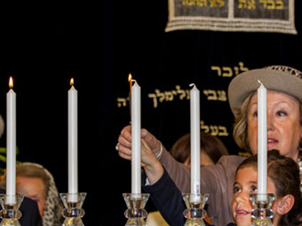 Mother and daughter light candles to commemorate Yom Hashoah.