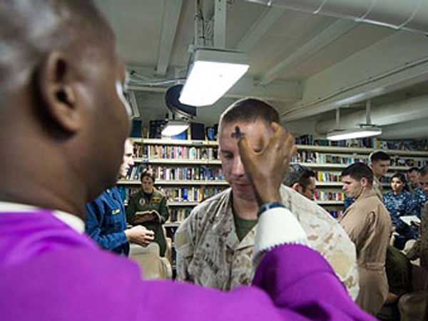 Navy chaplain distributes ashes to Marines on board USS Boxer.