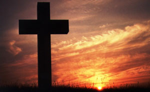 Large cross with setting sun behind